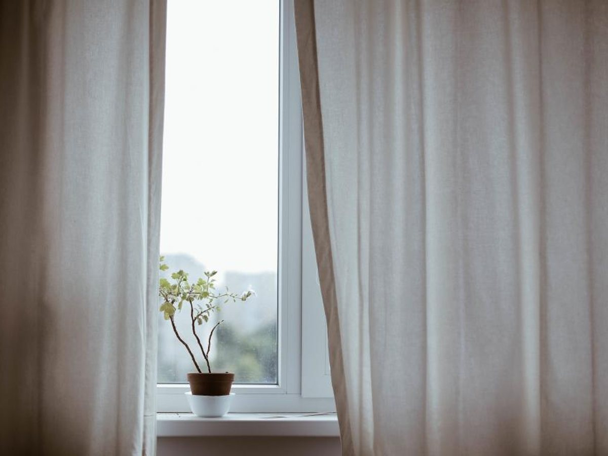 Daylight through a clean window behind soft curtains — representative imagery, not a specific Godvision Cleaning job