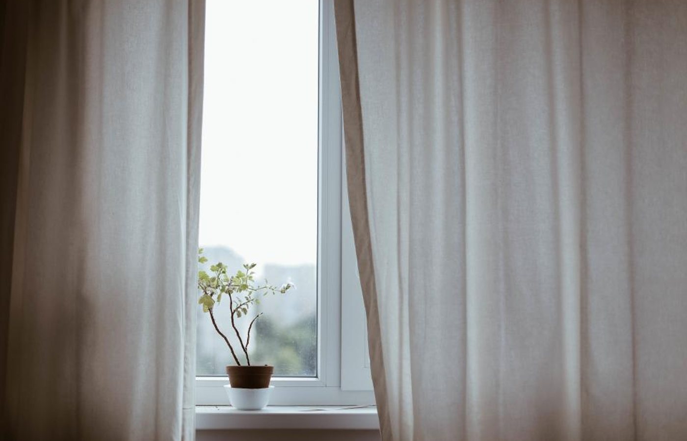 Daylight through a clean window behind soft curtains — representative imagery, not a specific Godvision Cleaning job